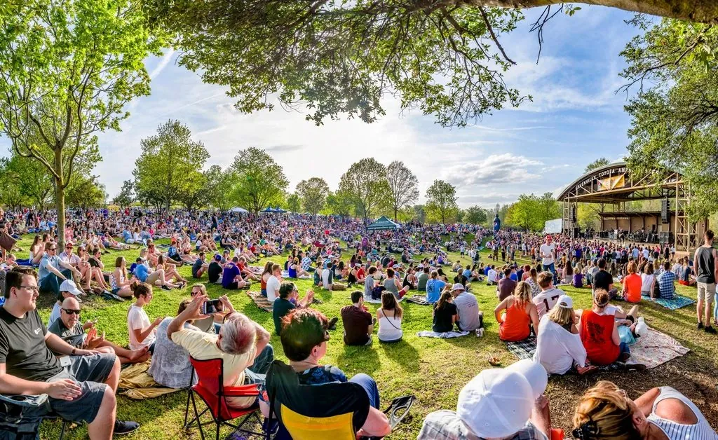 Een festivalpubliek op een groen veld in de zomer